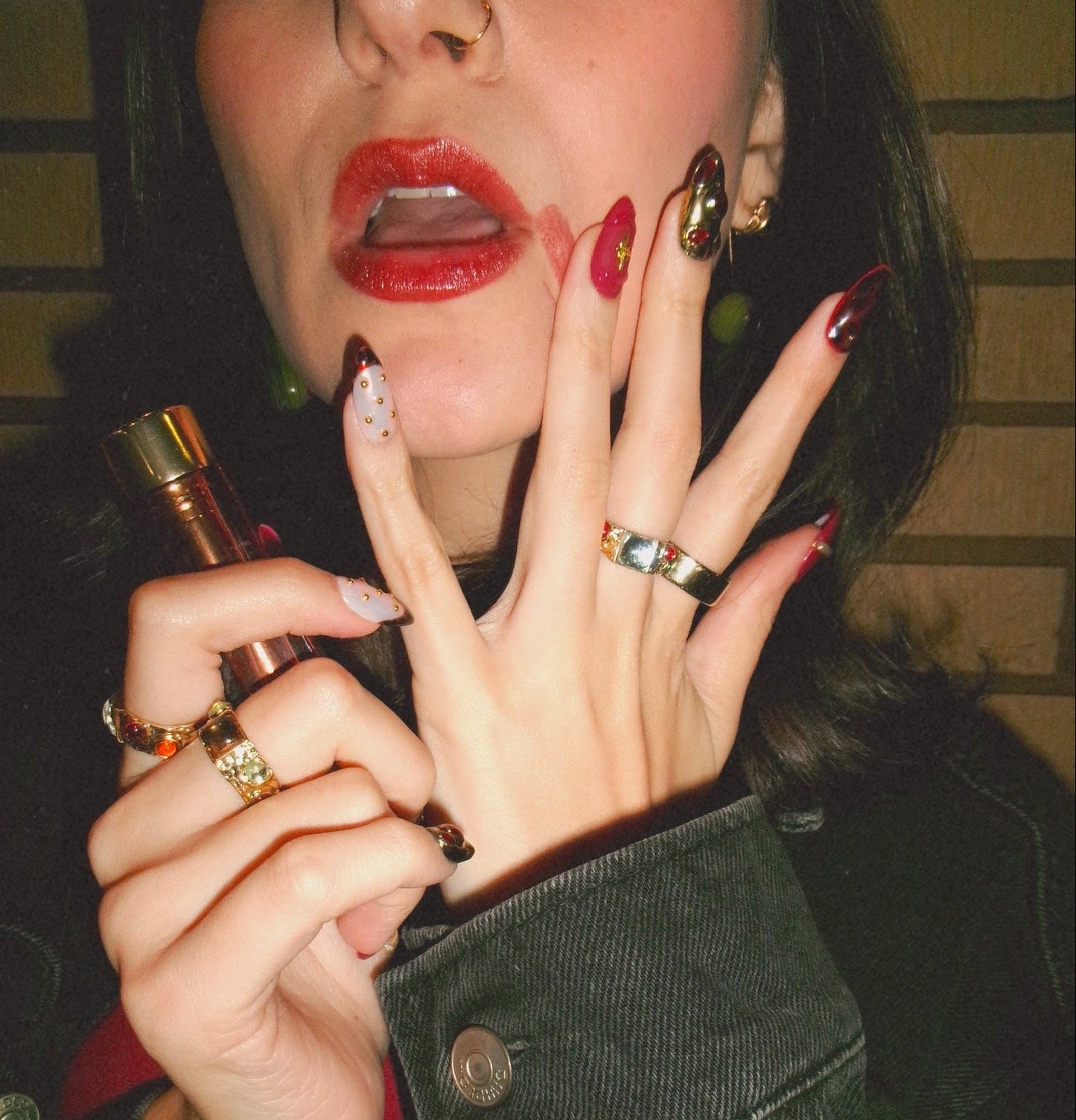 Person applying lipstick with close-up of nails and lips